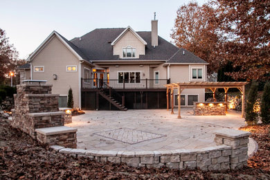 Large backyard concrete paver patio photo in Other
