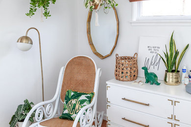 Photo of a tropical gender-neutral nursery in Los Angeles with white walls and medium hardwood floors.