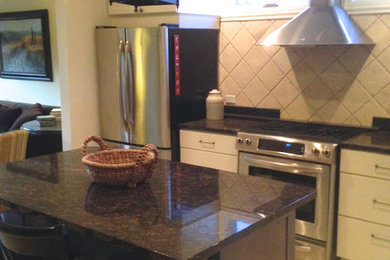 Open concept kitchen - mid-sized traditional l-shaped limestone floor open concept kitchen idea in Chicago with an undermount sink, recessed-panel cabinets, white cabinets, concrete countertops, beige backsplash, stone tile backsplash, stainless steel appliances and an island