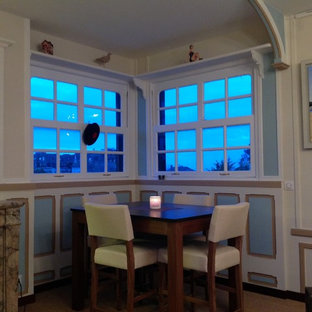 ルアーブルの中サイズのビーチスタイルのLDKの画像 (ベージュの壁、標準型暖炉、石材の暖炉まわり、ベージュの床)