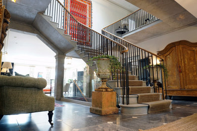 Foto de escalera suspendida clásica con escalones de piedra caliza, contrahuellas de piedra caliza y barandilla de metal