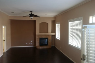 Foto de sala de estar cerrada actual de tamaño medio con paredes beige, suelo de madera oscura y todas las chimeneas