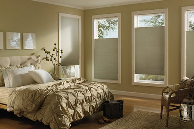 Inspiration for a mid-sized contemporary master medium tone wood floor and brown floor bedroom remodel in Milwaukee with beige walls and no fireplace