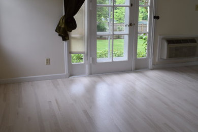 Design ideas for a mid-sized traditional living room in Boston with white walls, light hardwood floors and beige floor.