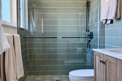 Example of a mid-sized master green tile ceramic tile, double-sink and wainscoting bathroom design in Denver with medium tone wood cabinets, a bidet, a drop-in sink, quartz countertops, white countertops and a freestanding vanity
