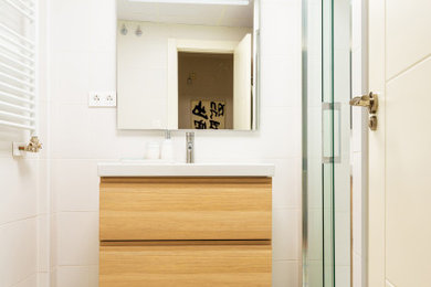 Modelo de cuarto de baño principal, único y flotante mediterráneo de tamaño medio con armarios con paneles lisos, puertas de armario de madera clara, ducha a ras de suelo y encimeras blancas