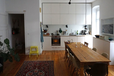 Shabby-Style Esszimmer mit weißer Wandfarbe und braunem Holzboden in Berlin