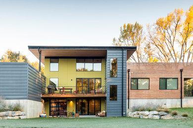 Large trendy yellow two-story mixed siding flat roof photo in Philadelphia