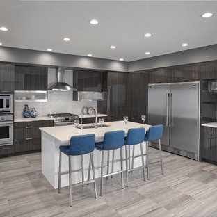 Inspiration för ett mellanstort funkis vit vitt kök, med en undermonterad diskho, luckor med lamellpanel, bänkskiva i kvarts, vitt stänkskydd, stänkskydd i porslinskakel, rostfria vitvaror, klinkergolv i porslin, flera köksöar och grått golv