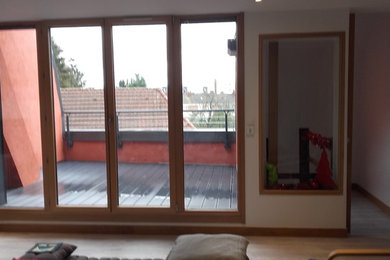 Cette image montre une salle de séjour design de taille moyenne et ouverte avec un mur orange et un sol gris.