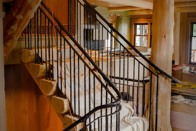 Large mountain style wooden u-shaped metal railing staircase photo in Boston with wooden risers