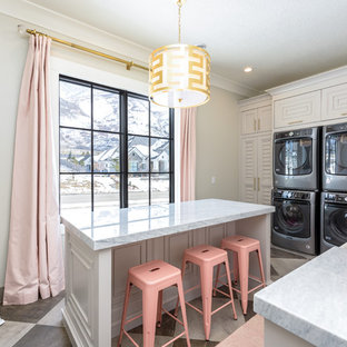 Design ideas for a large traditional l-shaped separated utility room in Salt Lake City with a belfast sink, louvered cabinets, a stacked washer and dryer, multi-coloured floors, grey worktops, marble worktops, grey cabinets and grey walls.