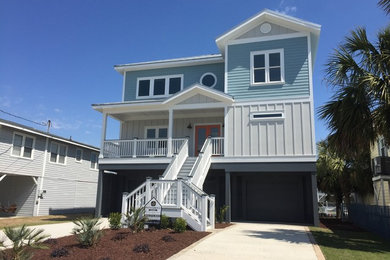 Coastal two-story concrete fiberboard exterior home idea in Other with a metal roof
