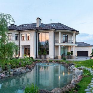 На фото: большие, двухэтажные фасады частных домов бежевого цвета в стиле современная классика с вальмовой крышей