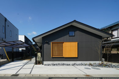 Idée de décoration pour une façade de maison métallique et noire en planches et couvre-joints de plain-pied avec un toit à deux pans, un toit en métal et un toit noir.