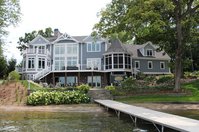 Inspiration for a huge timeless gray three-story wood exterior home remodel in Milwaukee with a shingle roof