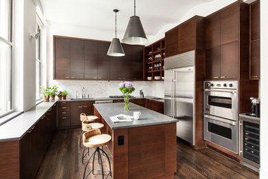 Photo of a large contemporary u-shaped kitchen in New York with an undermount sink, flat-panel cabinets, dark wood cabinets, soapstone benchtops, white splashback, marble splashback, stainless steel appliances, with island, brown floor and dark hardwood floors.