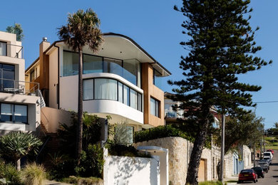 Modern three-storey white exterior in Sydney with stone veneer and a flat roof.