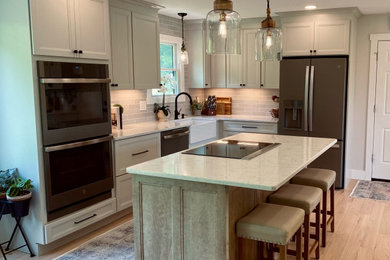 Kitchen - country kitchen idea in Philadelphia with a farmhouse sink, shaker cabinets, white cabinets, quartz countertops, an island and white countertops