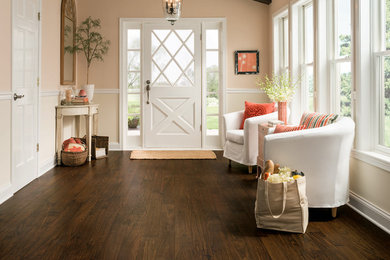 Design ideas for a large country foyer in Orange County with pink walls, dark hardwood floors, a single front door, a white front door and brown floor.