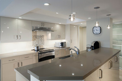 Inspiration for a mid-sized contemporary galley light wood floor enclosed kitchen remodel in Hawaii with an undermount sink, flat-panel cabinets, beige cabinets, quartz countertops, white backsplash, stainless steel appliances and a peninsula