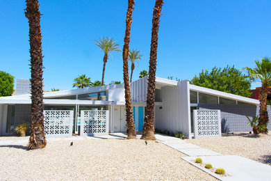 Large mid-century modern white one-story brick exterior home photo in Other