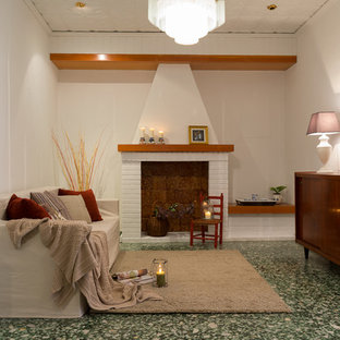 Design ideas for a mediterranean open plan living room in Valencia with a standard fireplace, a brick fireplace surround and green floors.