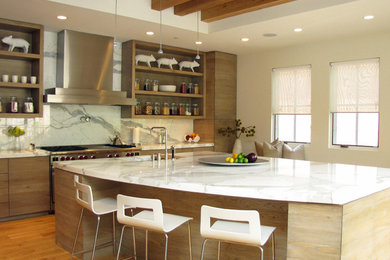 Example of a trendy medium tone wood floor kitchen design in Chicago with an undermount sink, flat-panel cabinets, light wood cabinets, white backsplash, stone slab backsplash, stainless steel appliances, marble countertops and an island