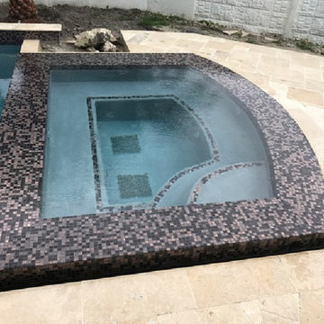 Contemporary jacuzzi with recycled glass mosaic border