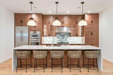 Inspiration for a large contemporary single-wall light wood floor open concept kitchen remodel in San Francisco with an undermount sink, flat-panel cabinets, medium tone wood cabinets, quartz countertops, gray backsplash, ceramic backsplash, stainless steel appliances, an island and white countertops