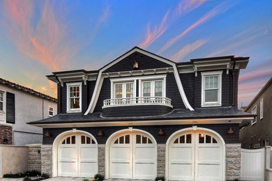 Design ideas for a mid-sized traditional two-storey black exterior in Los Angeles with vinyl siding and a clipped gable roof.