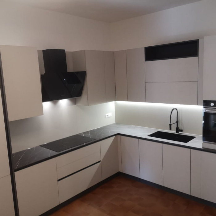 Cucina angolare Anta Beton Perla con maniglia a gola brunita. Top in HPL finitura Pulpis Dark con schienale uguale all'anta. Completano l' induzione da 77cm, il forno, la lavastoviglie e il frigo ad i