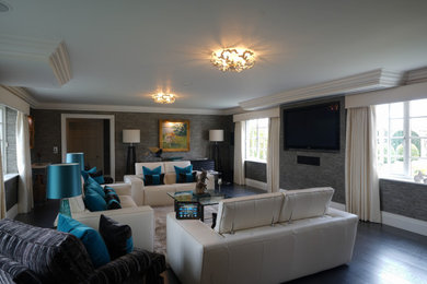 Diseño de salón para visitas contemporáneo grande con paredes grises, suelo de madera oscura, pared multimedia y suelo marrón