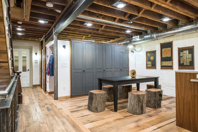 Example of a mid-sized urban light wood floor and brown floor enclosed dining room design in Boston with white walls and no fireplace