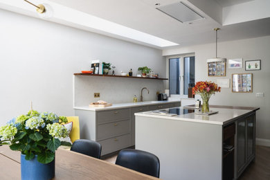 Example of a large minimalist eat-in kitchen design in London with an island