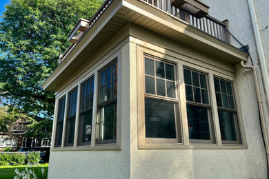 Example of a small classic beige one-story stucco house exterior design in Minneapolis with a black roof
