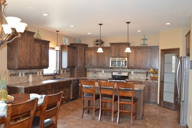 Inspiration for a mid-sized rustic l-shaped laminate floor and beige floor eat-in kitchen remodel in Other with a drop-in sink, recessed-panel cabinets, dark wood cabinets, granite countertops, beige backsplash, stainless steel appliances, an island and ceramic backsplash