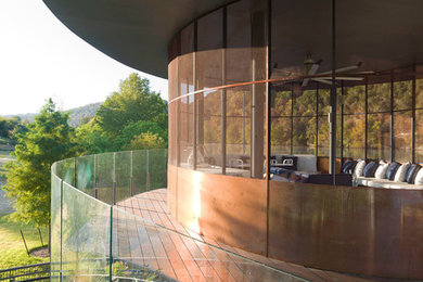 Large mountain style backyard deck photo in Austin with a pergola