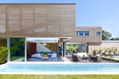 Contemporary two-storey exterior in New York with wood siding and a flat roof.