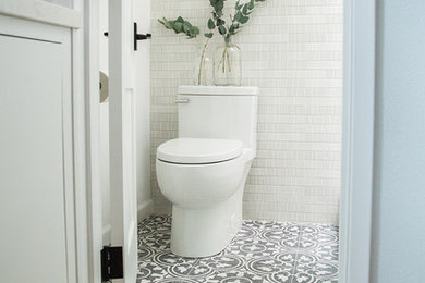 Small minimalist 3/4 white tile and ceramic tile cement tile floor and black floor bathroom photo in Orange County with flat-panel cabinets, white cabinets, a one-piece toilet, white walls, an undermount sink, quartz countertops and white countertops