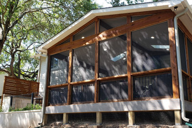 This is an example of a large eclectic concrete porch design in Austin with a roof extension.
