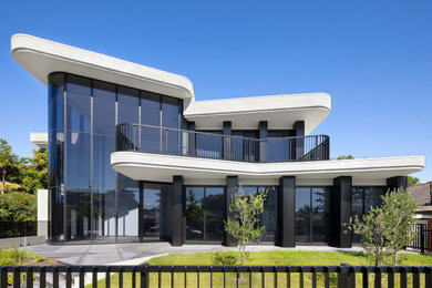 Immagine della facciata di un appartamento grande contemporaneo a due piani con rivestimento in cemento, tetto piano, copertura in metallo o lamiera e tetto bianco