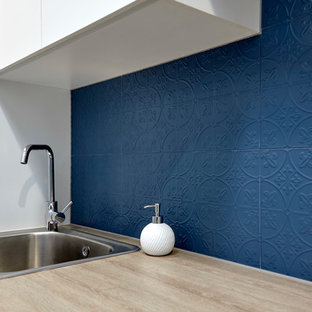 Inspiration for a small contemporary single-wall separated utility room in Adelaide with a built-in sink, flat-panel cabinets, white cabinets, laminate countertops, blue walls, porcelain flooring, a side by side washer and dryer, grey floors and orange worktops.