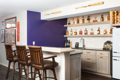 Inspiration for a seated home bar remodel in Kansas City with an undermount sink, light wood cabinets and stone tile backsplash