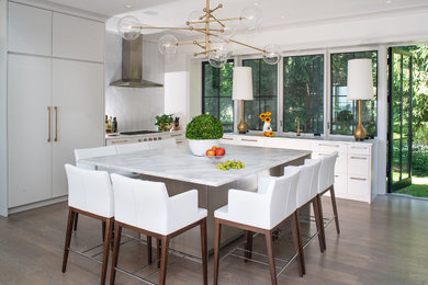 Example of a minimalist l-shaped medium tone wood floor eat-in kitchen design in Other with flat-panel cabinets, white backsplash, glass tile backsplash and an island
