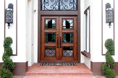 Large mediterranean front door in Miami with brick floors, a double front door and a medium wood front door.