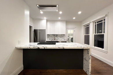 Eat-in kitchen - mid-sized contemporary galley medium tone wood floor and brown floor eat-in kitchen idea in San Francisco with a single-bowl sink, shaker cabinets, black cabinets, quartz countertops, white backsplash, quartz backsplash, stainless steel appliances, an island and white countertops