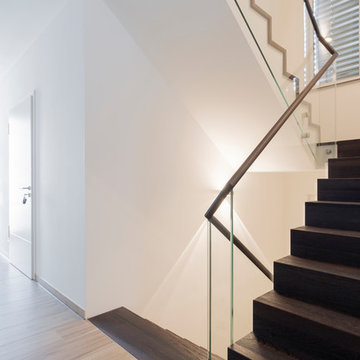 Faltwerk aus Wenge mit Weißglas auf Beton