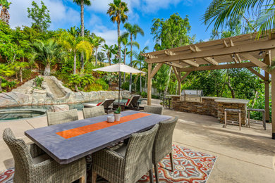 Inspiration for a large transitional backyard concrete patio remodel in San Diego with a bbq area and a pergola