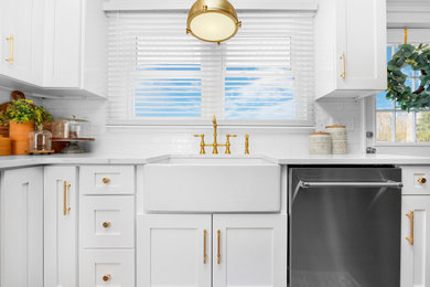 Eat-in kitchen - large transitional l-shaped medium tone wood floor and brown floor eat-in kitchen idea in Newark with a farmhouse sink, shaker cabinets, white cabinets, quartzite countertops, white backsplash, subway tile backsplash, stainless steel appliances, an island and white countertops